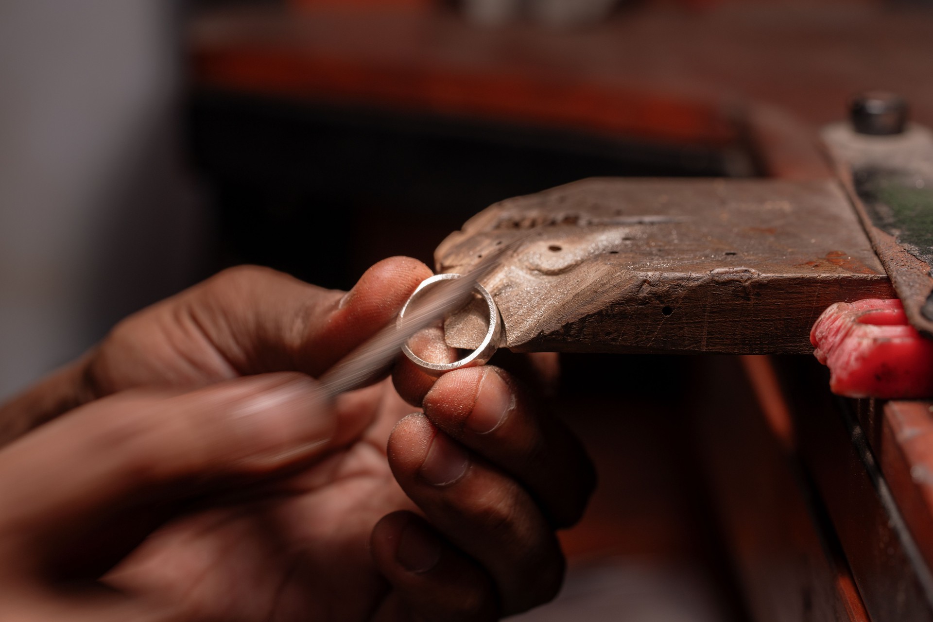 Close up of Jeweler's Hand Polishing Filing a Silver Ring on a Wooden Bench Pin. silver gold 925 sterling silver exclusively by Deep Shine Jewellers jewellery DSJ 
